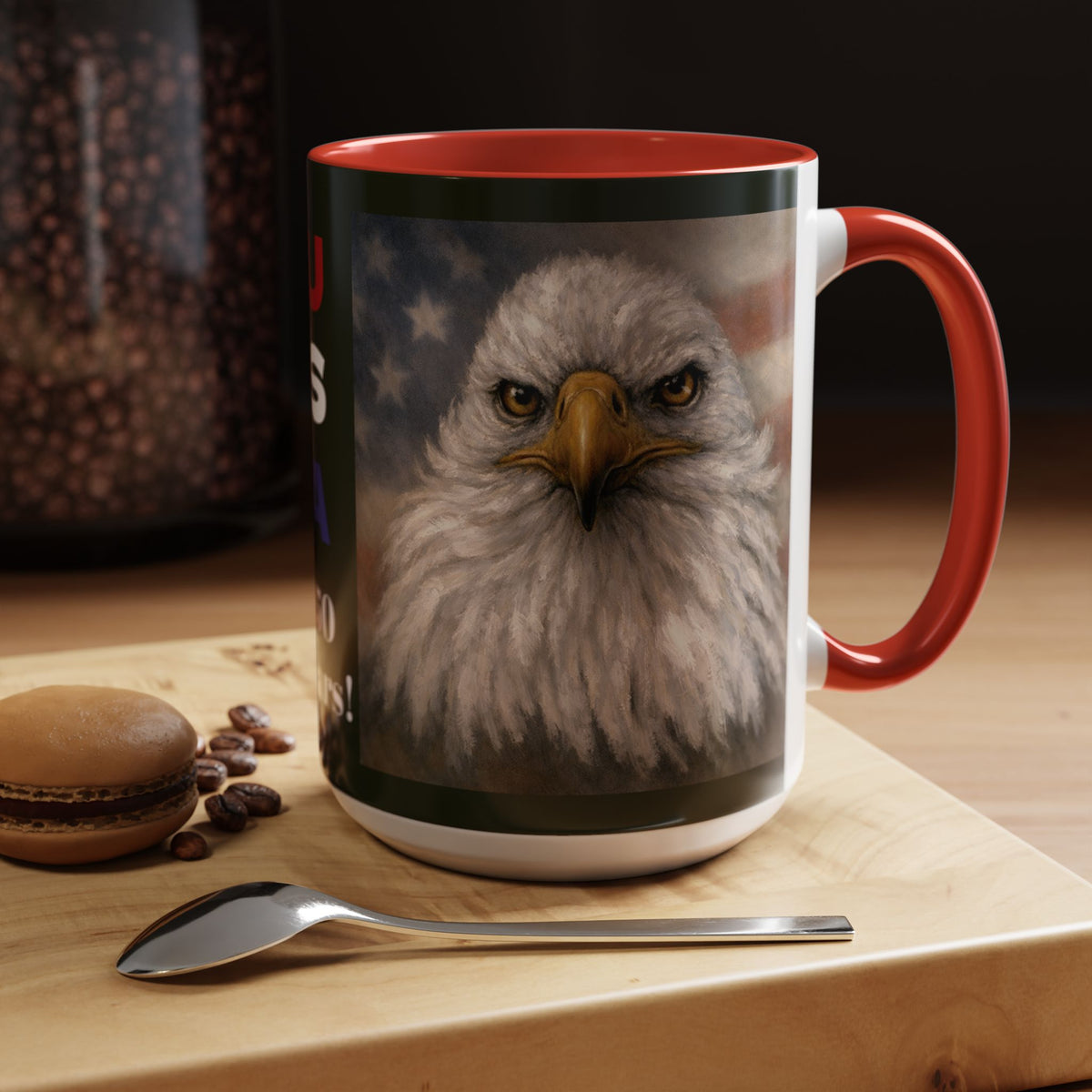 A ceramic mug with a red handle and interior, featuring a printed graphic of a bald eagle's face over a blurred American flag background.