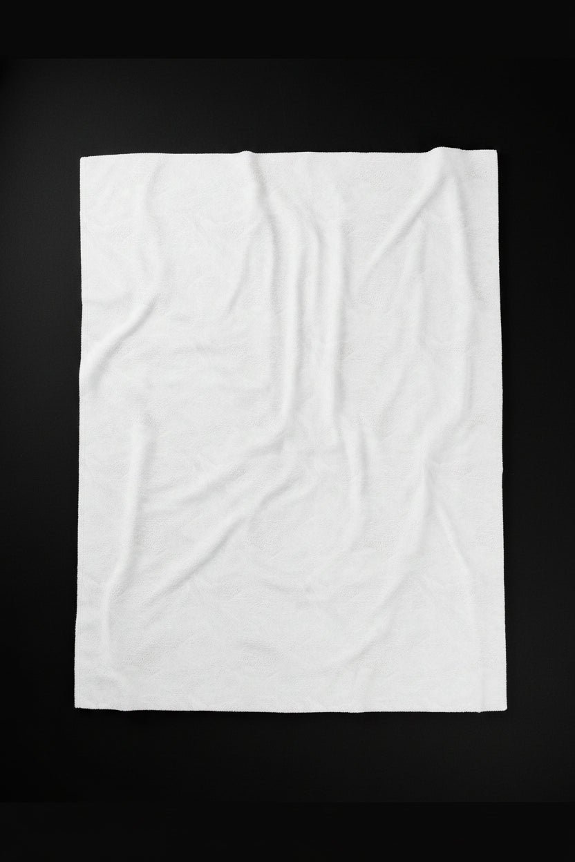 A white textured fabric on back of throw blanket with a subtle embossed floral pattern