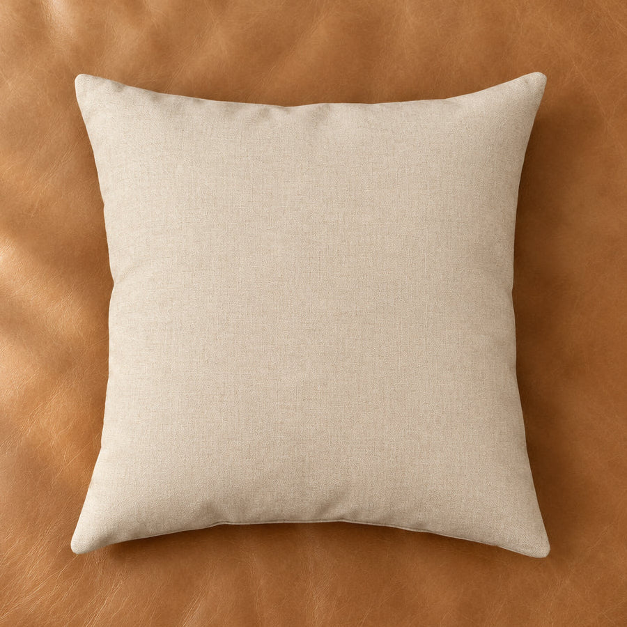 A square beige throw pillow with a subtle woven texture