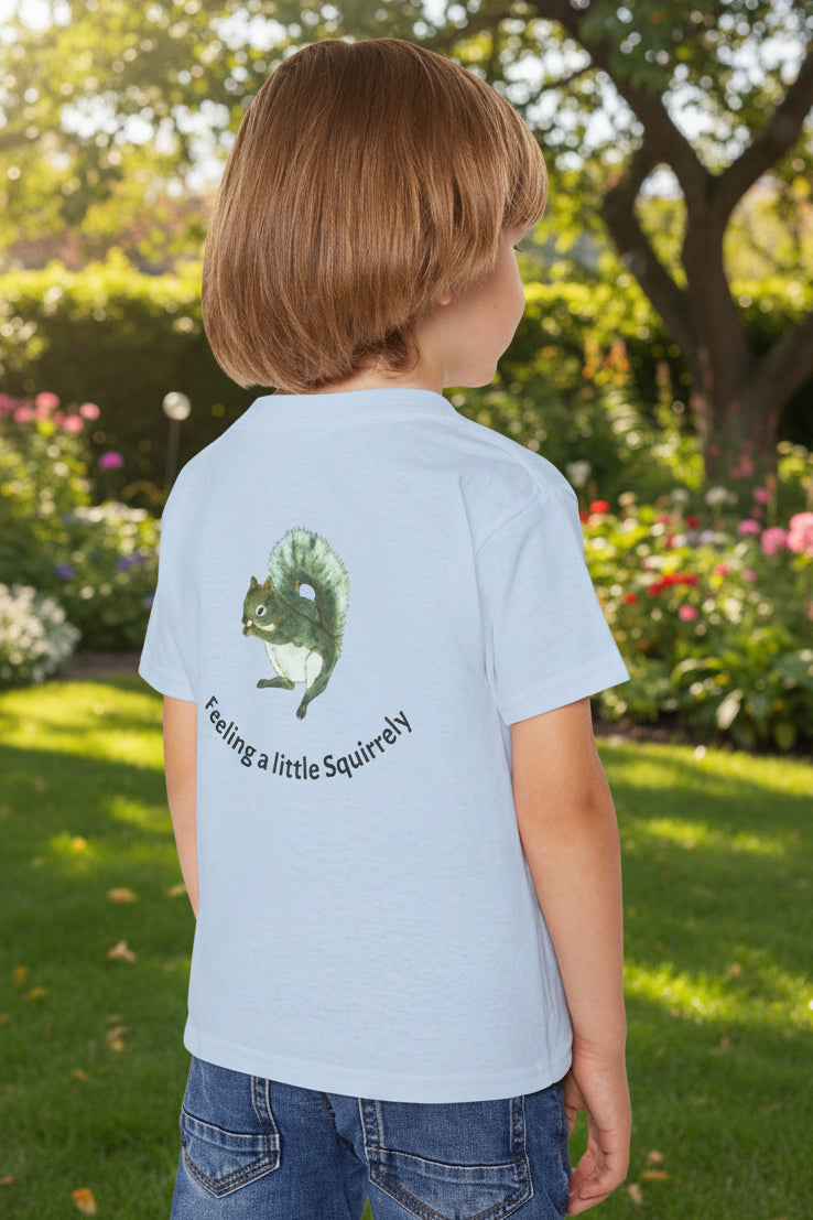 A light blue child's t-shirt, viewed from the back. The shirt features a painted graphic of a squirrel with the text 'Feeling a little Squirrelly'