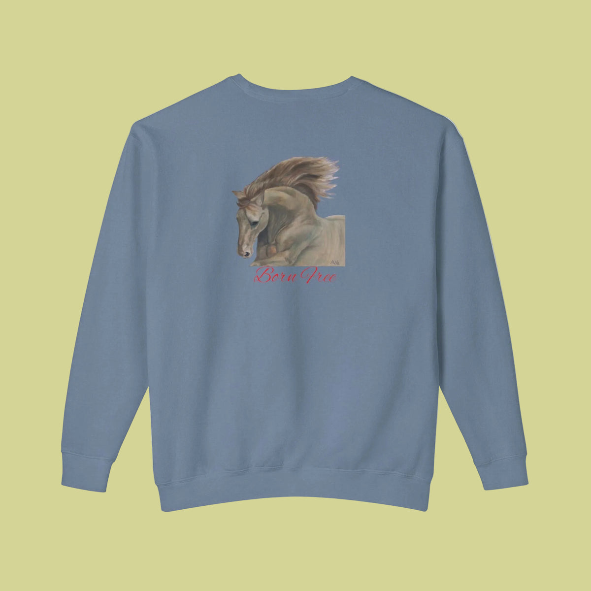 A blue jean colored crewneck sweatshirt shown from the back, featuring a graphic print of a horse with its mane blowing in the wind, and the text 'Born Free' in red cursive below it.