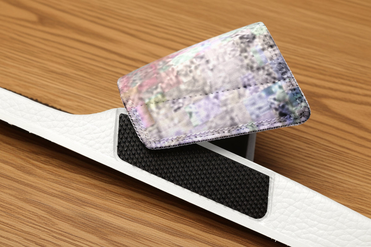 A close-up of a white textured strap, featuring a black textured grip panel and a flap with an iridescent, multicolor abstract design.
