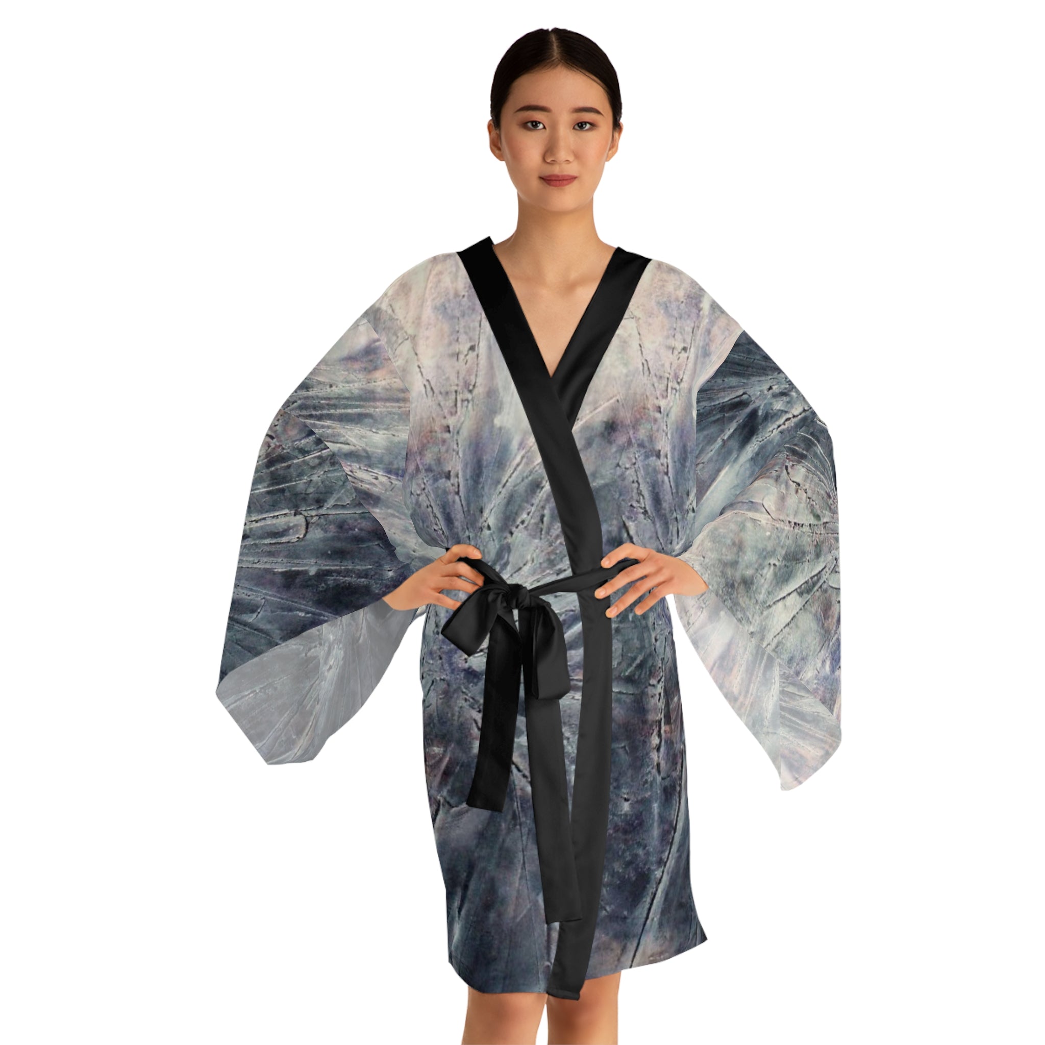 Woman wearing a patterned kimono with a black belt on a white background