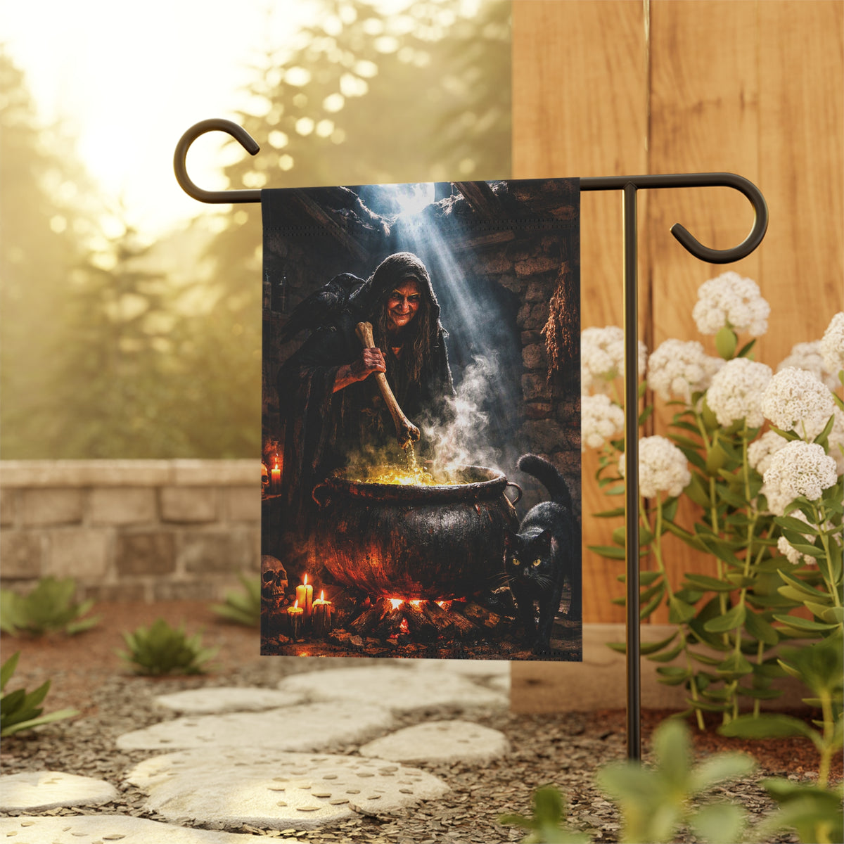 A vertical garden flag featuring a witch stirring a cauldron with a cauldron flame, black cat, crow and cauldron