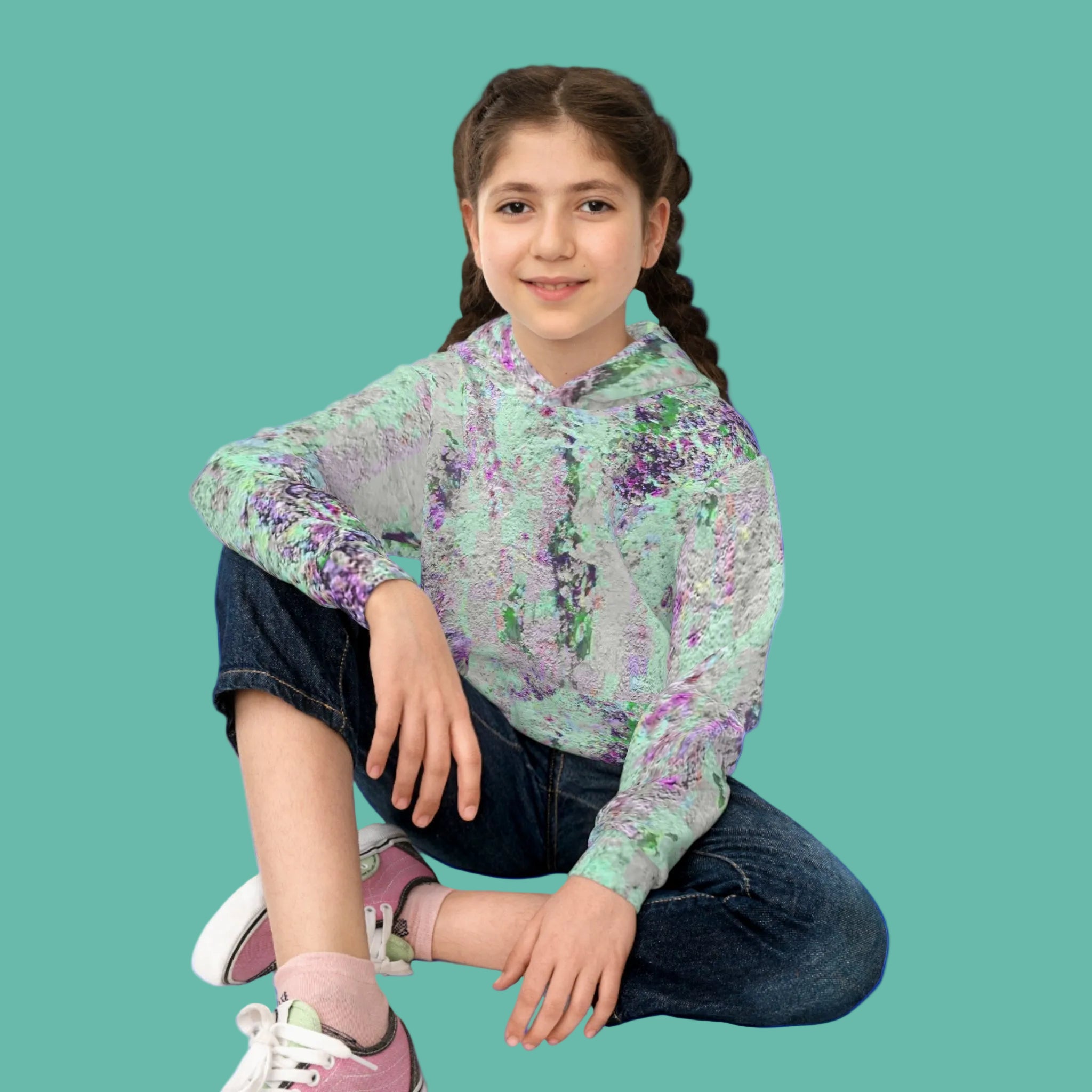 Young girl wearing an abstract art hoodie sitting on the floor
