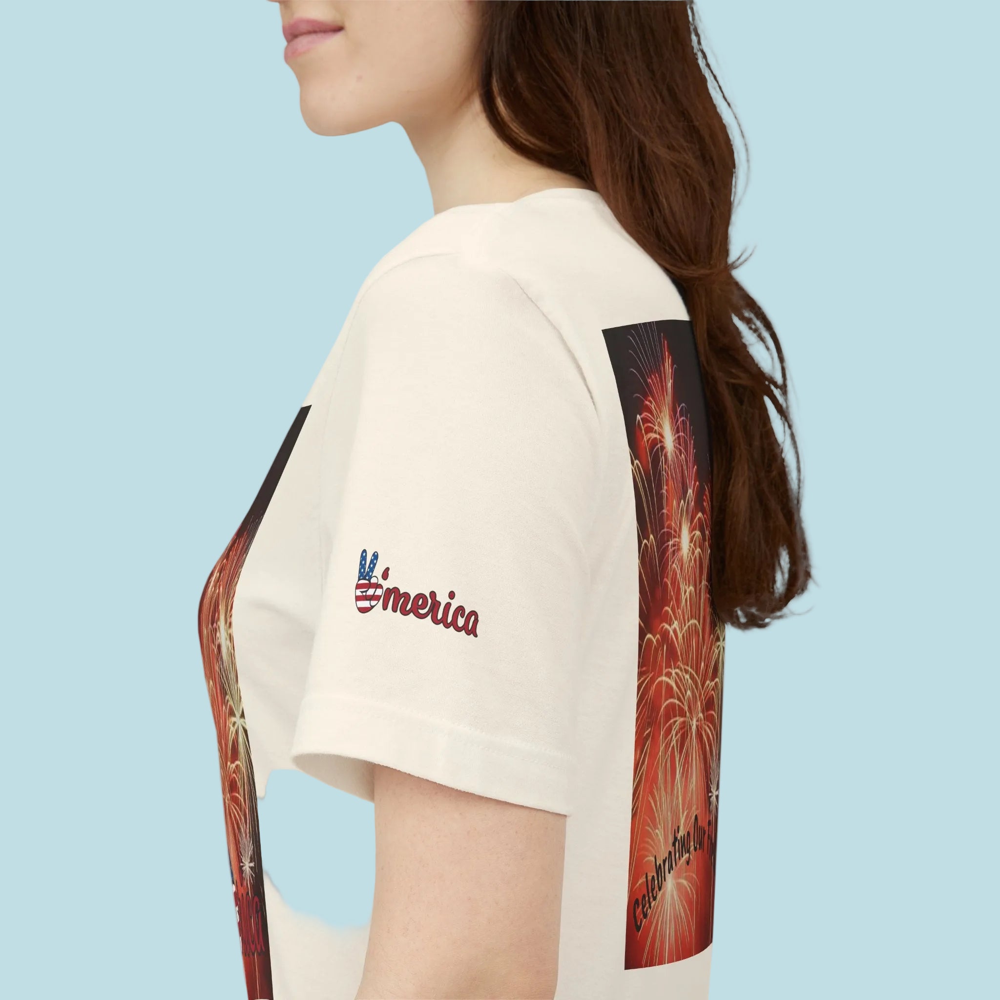 Person wearing a white t-shirt with colorful graphic designs on the sleeves.