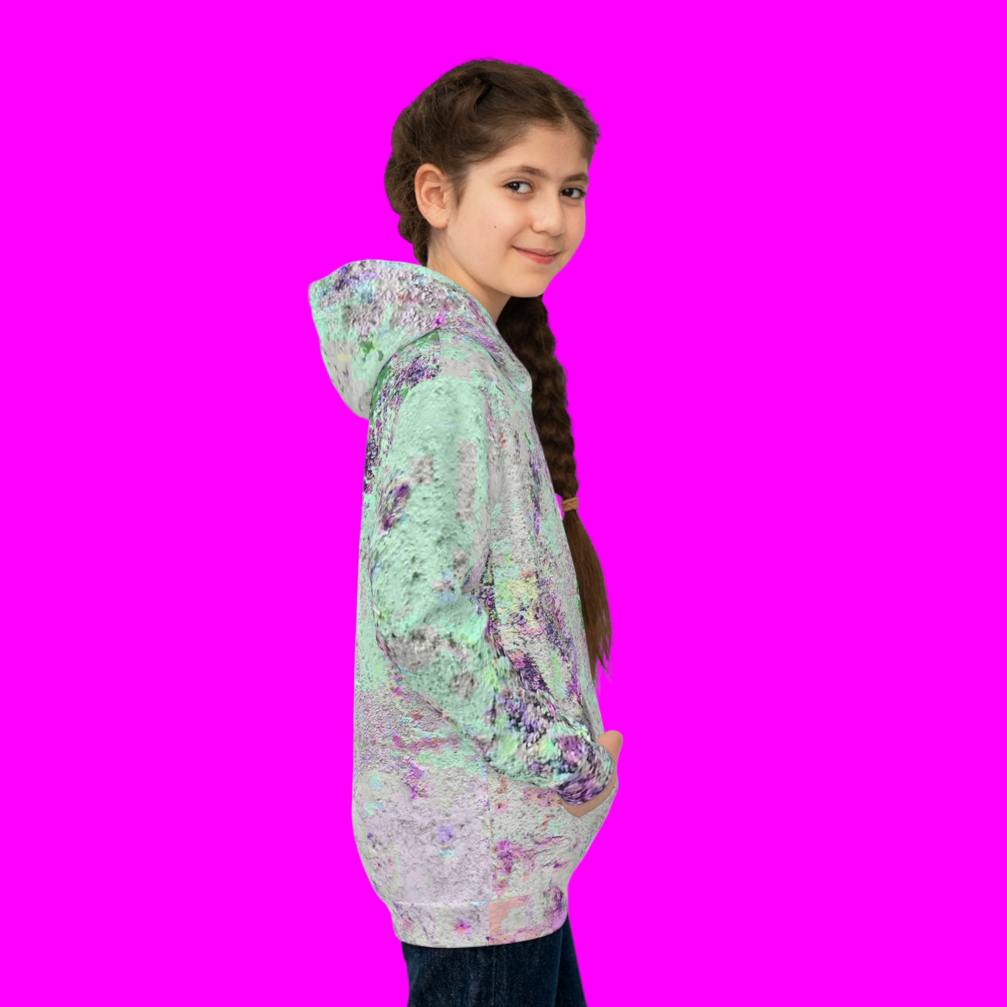 Girl in side view wearing a Unique abstract hoodie on a pink background