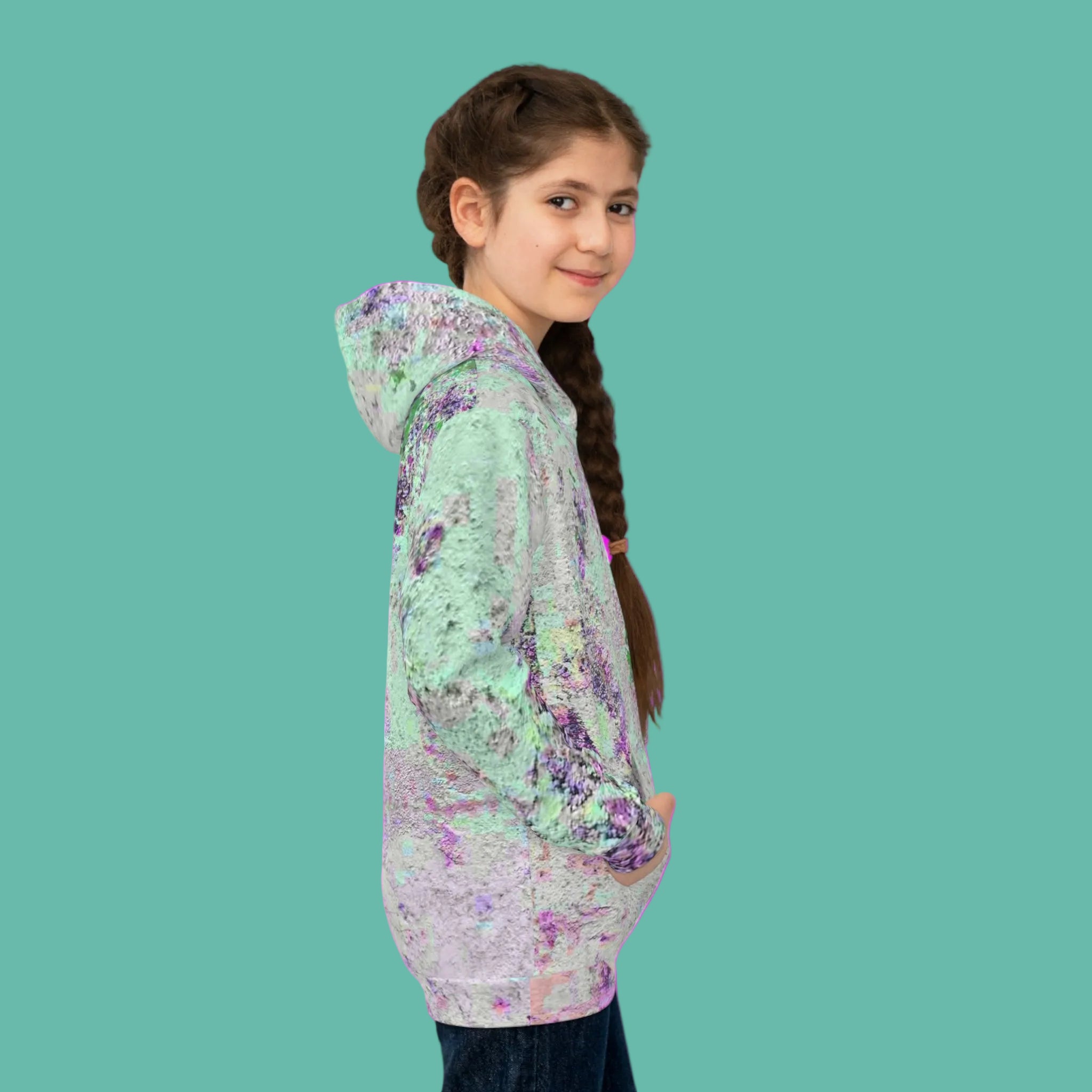 Girl in side view wearing a Unique abstract hoodie on a pink background