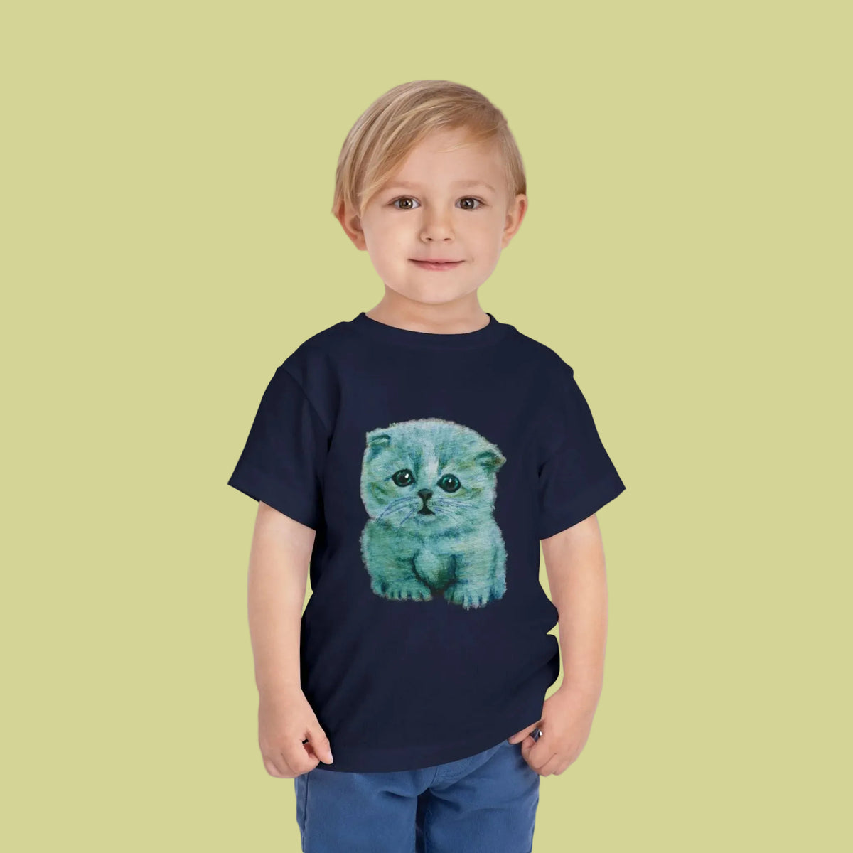 A toddler boy wearing a navy blue t-shirt with a printed graphic of a fluffy light blue kitten - in soft cotton
