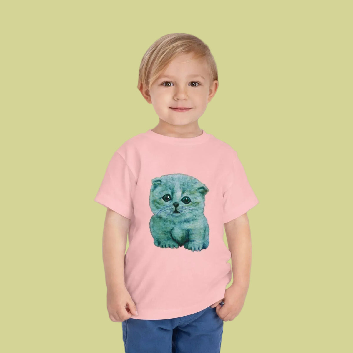 A toddler wearing a light pink short-sleeve t-shirt with a watercolor-style graphic of a blue-gray kitten on the front.