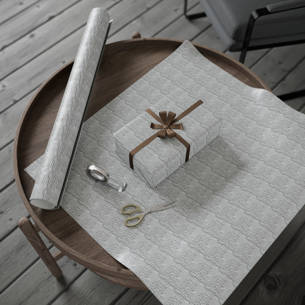 White textured wrapping paper with a gift and scissors on a wooden table