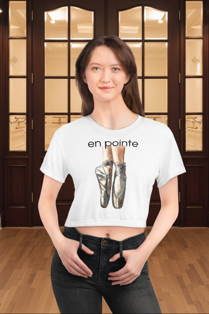 White cropped t-shirt with a watercolor of ballet shoes and the text 'en pointe'. Choose from white or black seam thread.
