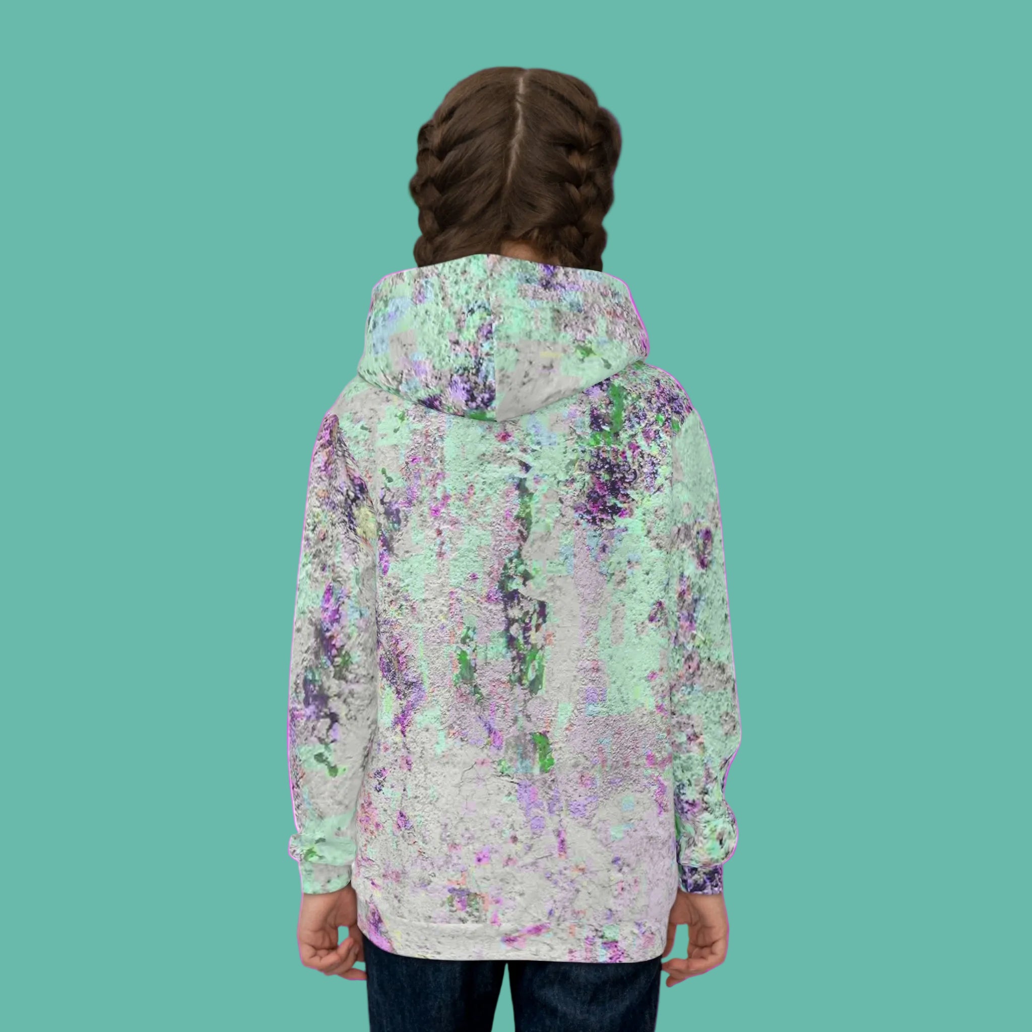 Person wearing a colorful abstract patterned jacket on a pink background