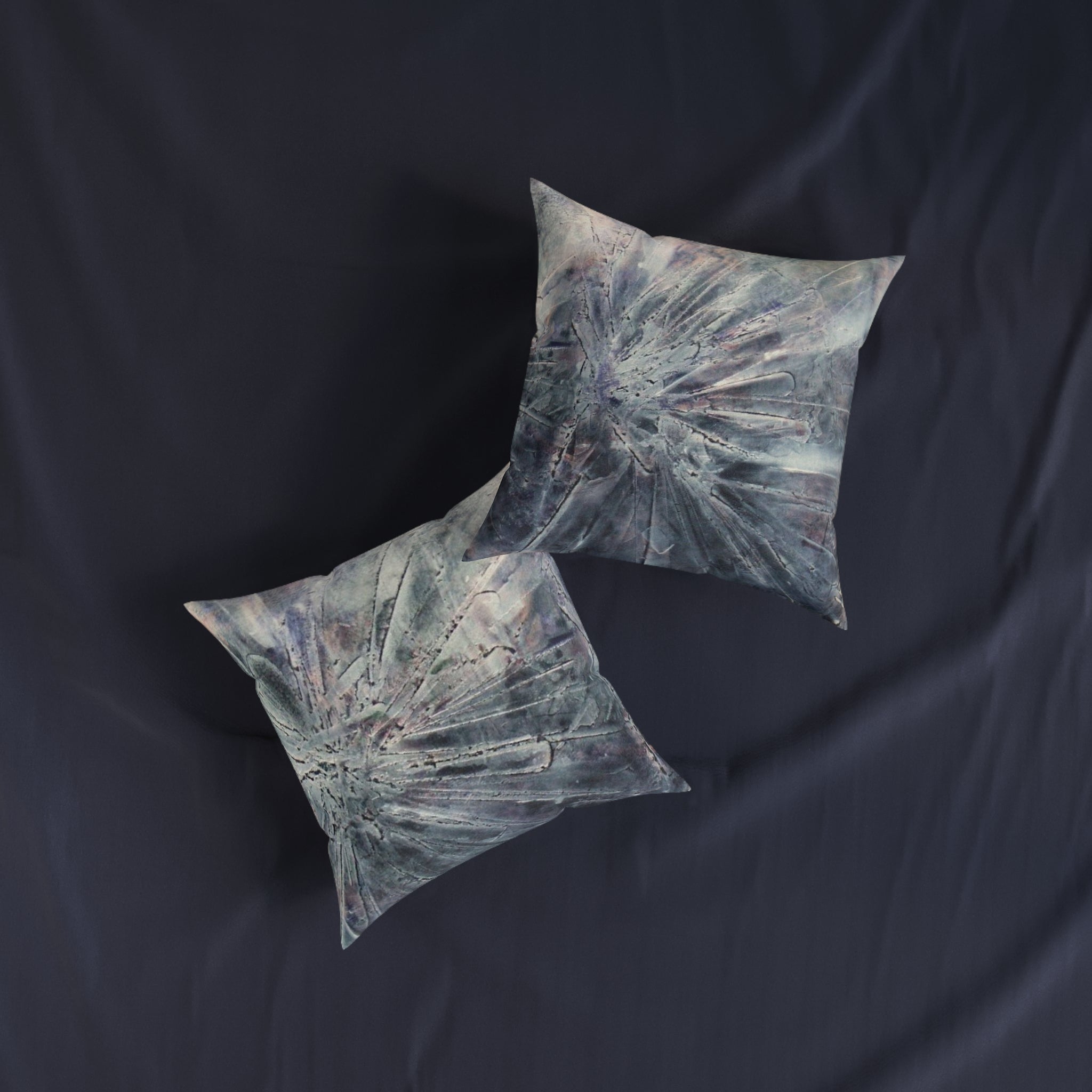 decorative pillows with abstract design on a dark fabric background