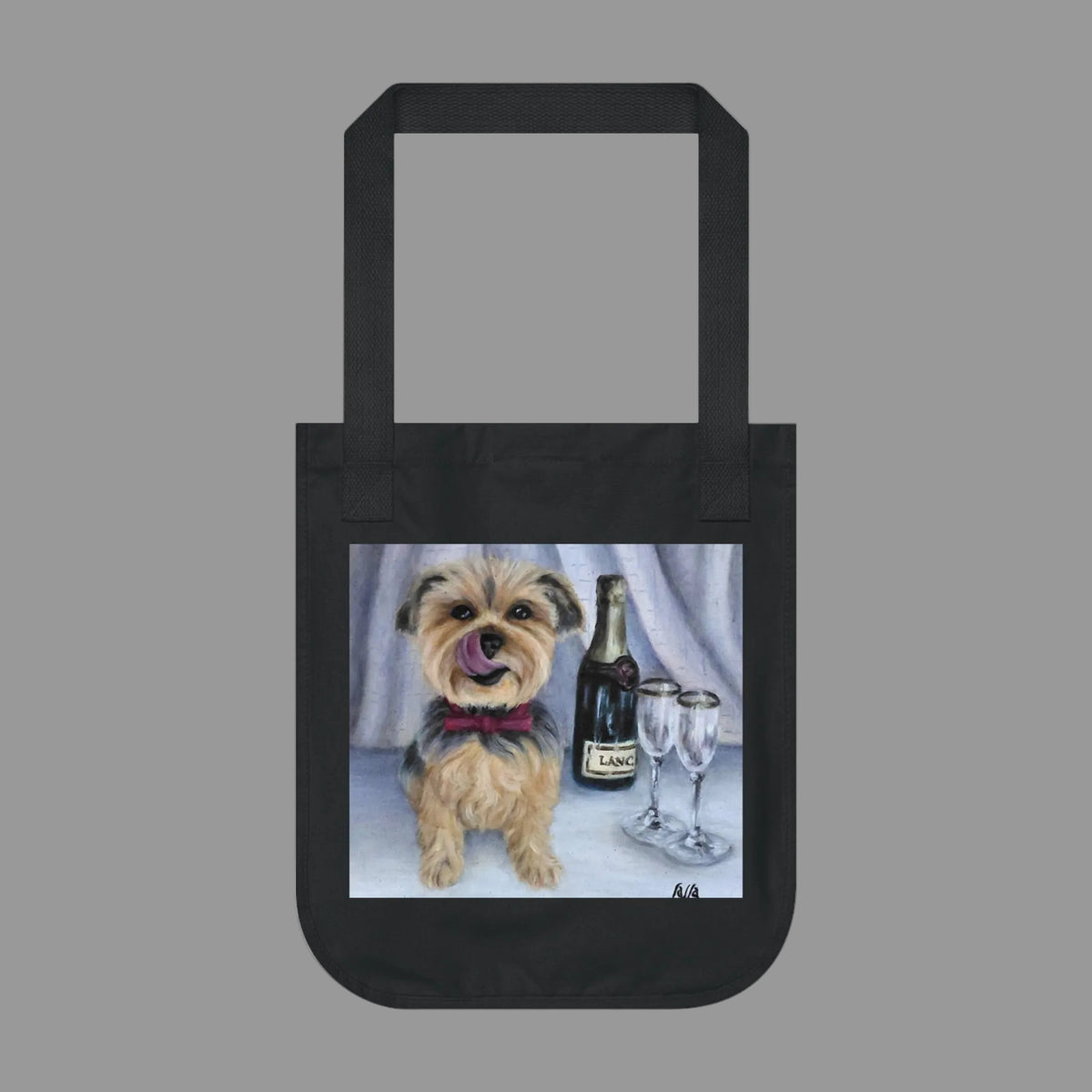 A black canvas tote bag with a printed illustration of a small tan and gray dog wearing a red bow tie, sitting next to a wine bottle and two wine glasses 
