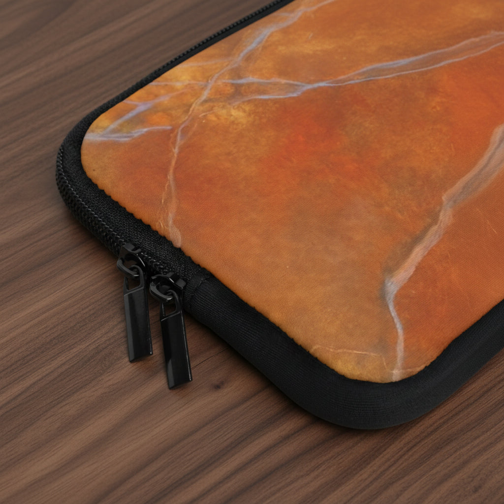 Close-up of a red orange marble design laptop sleeve and black zippers