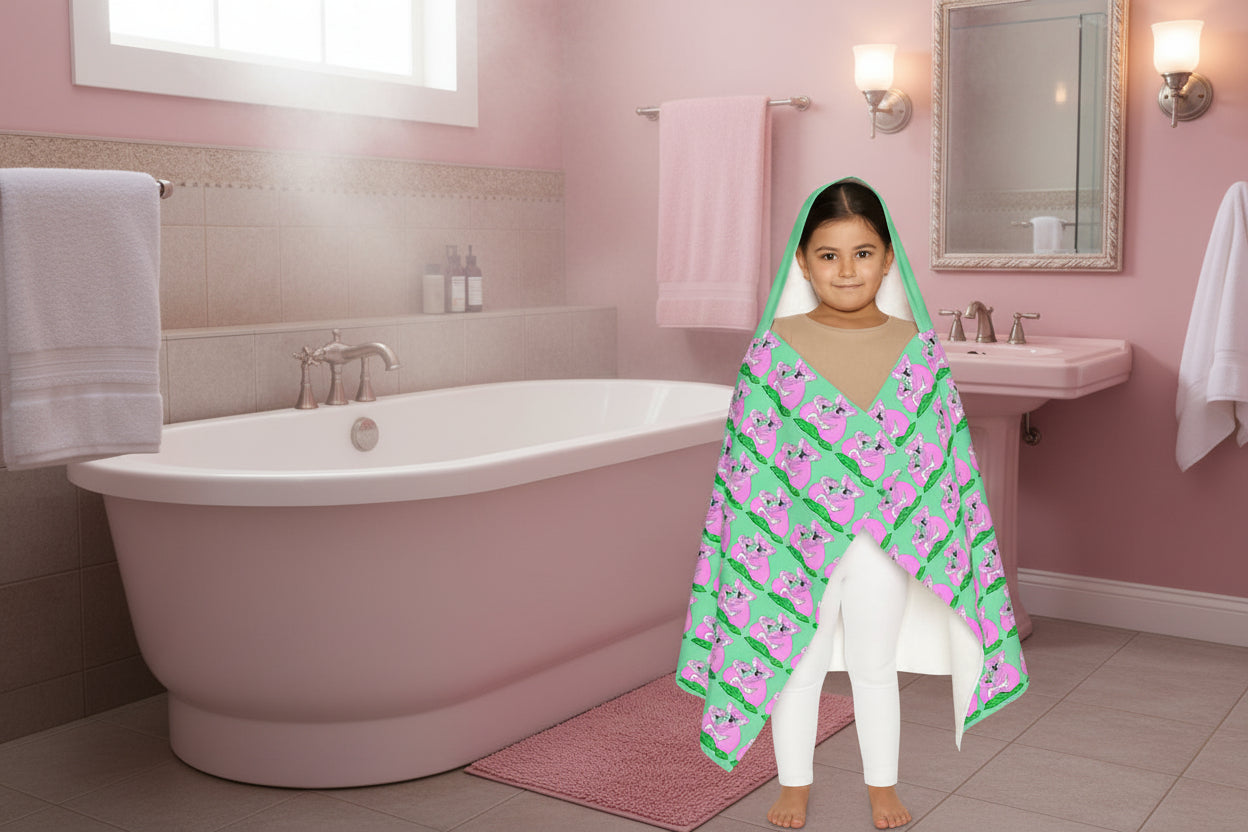 Child wearing a green and pink patterned hooded soft towel on a white background