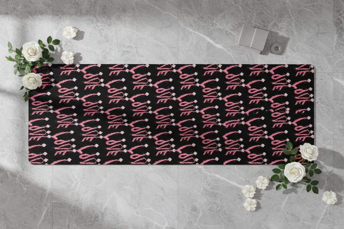 Black yoga mat with pink 'LOVE' design on non-slip surface - durable but soft
