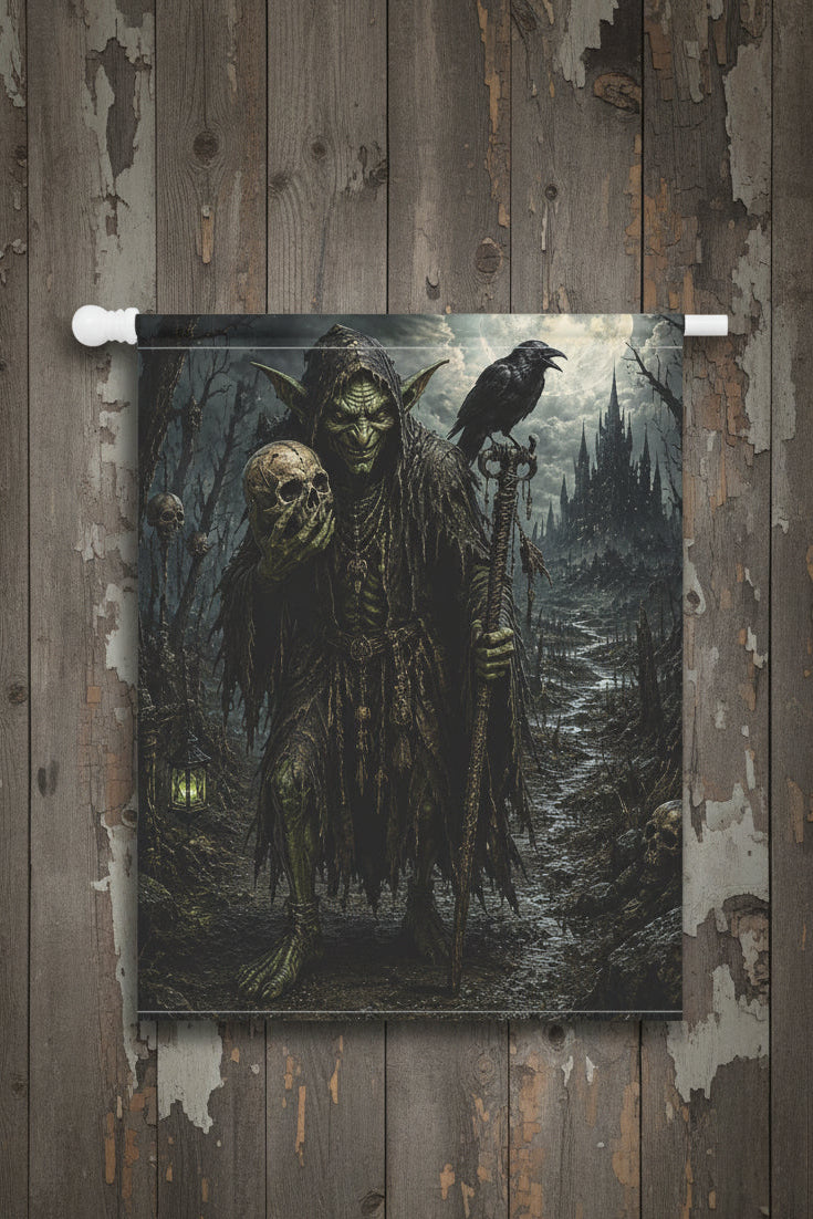 A vertical wall flag hanging from a white rod, featuring a dark gothic illustration of a green-skinned demon holding a skull, with a raven perched on its shoulder and a ruined castle in the background.