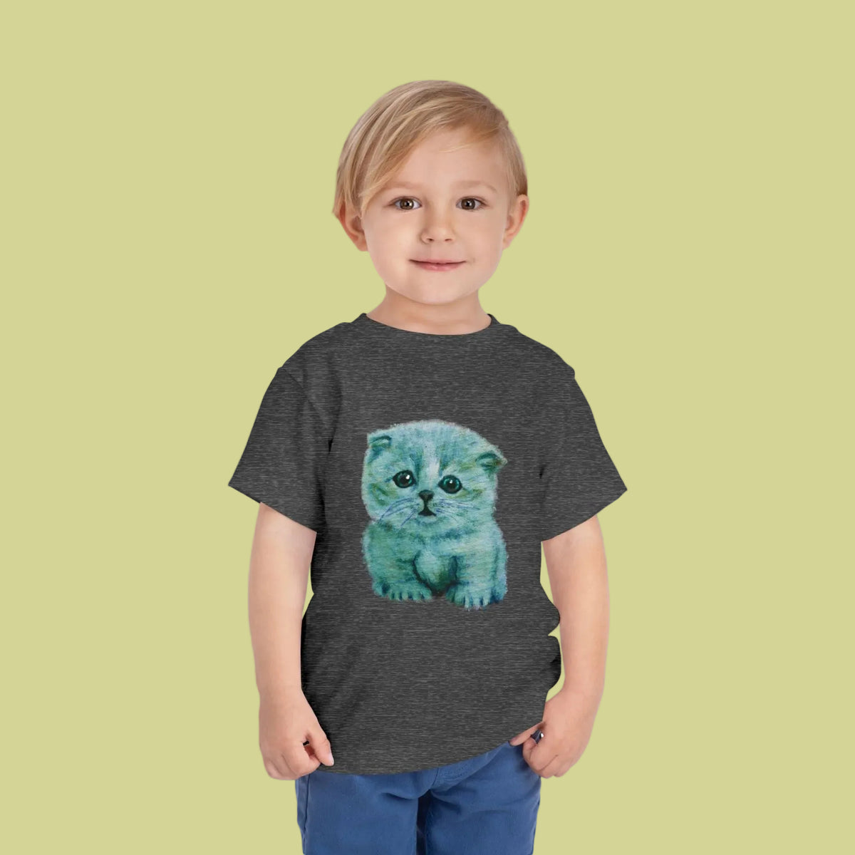 A toddler boy wearing a dark heather gray t-shirt with a colorful graphic of a blue kitten on the front - 4 colors available