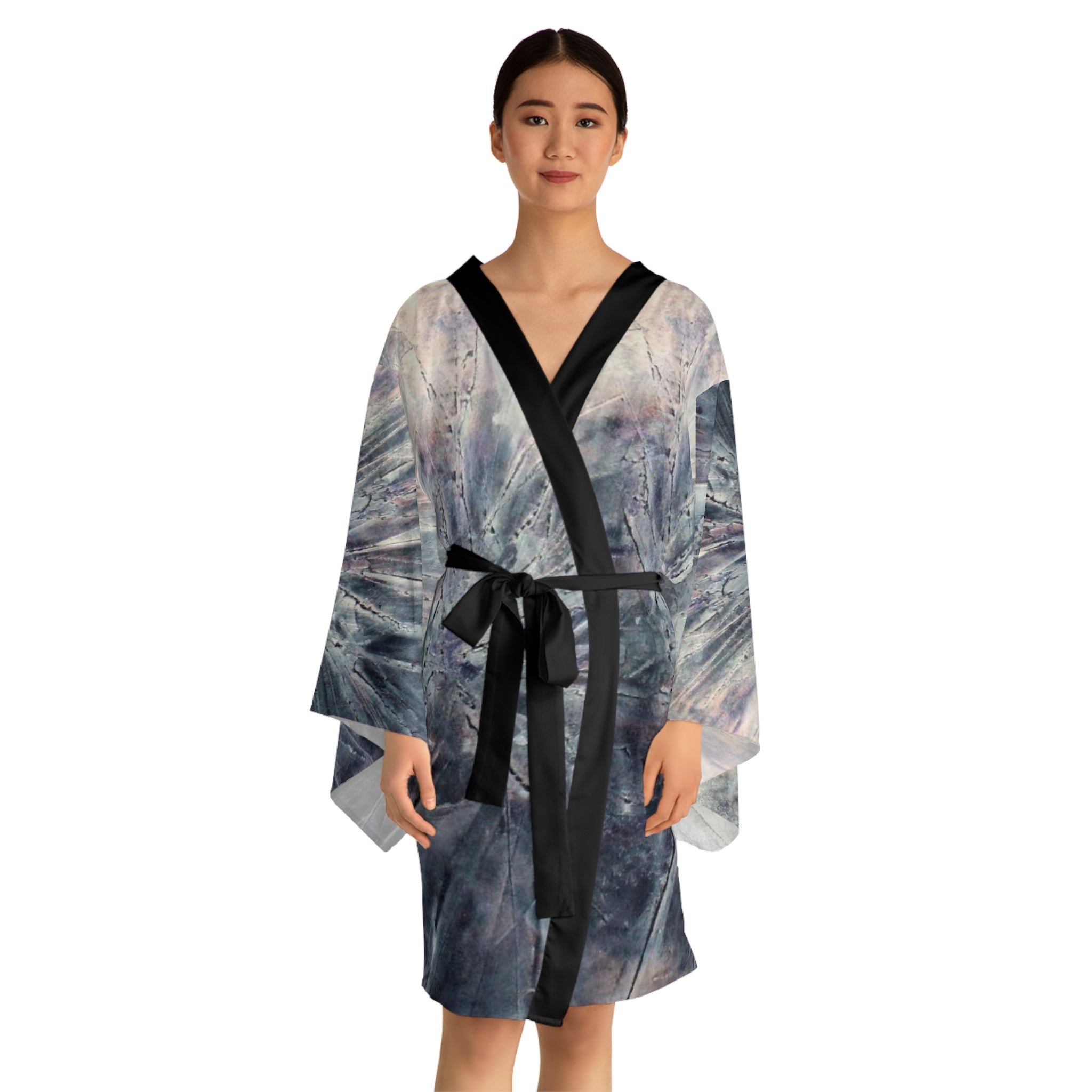 Woman wearing a patterned robe with a black belt on a white background