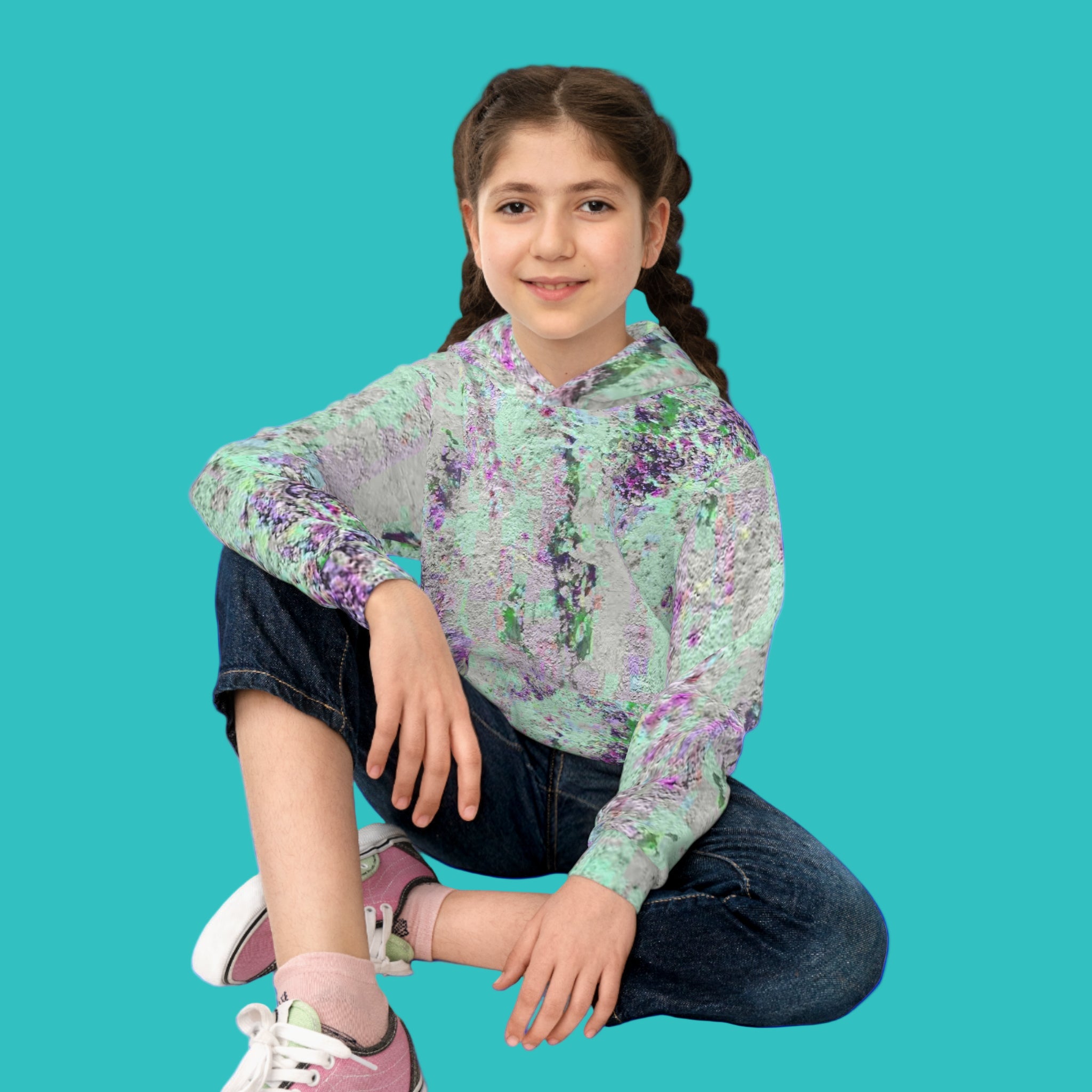 Young girl wearing an abstract art  hoodie sitting on the floor 