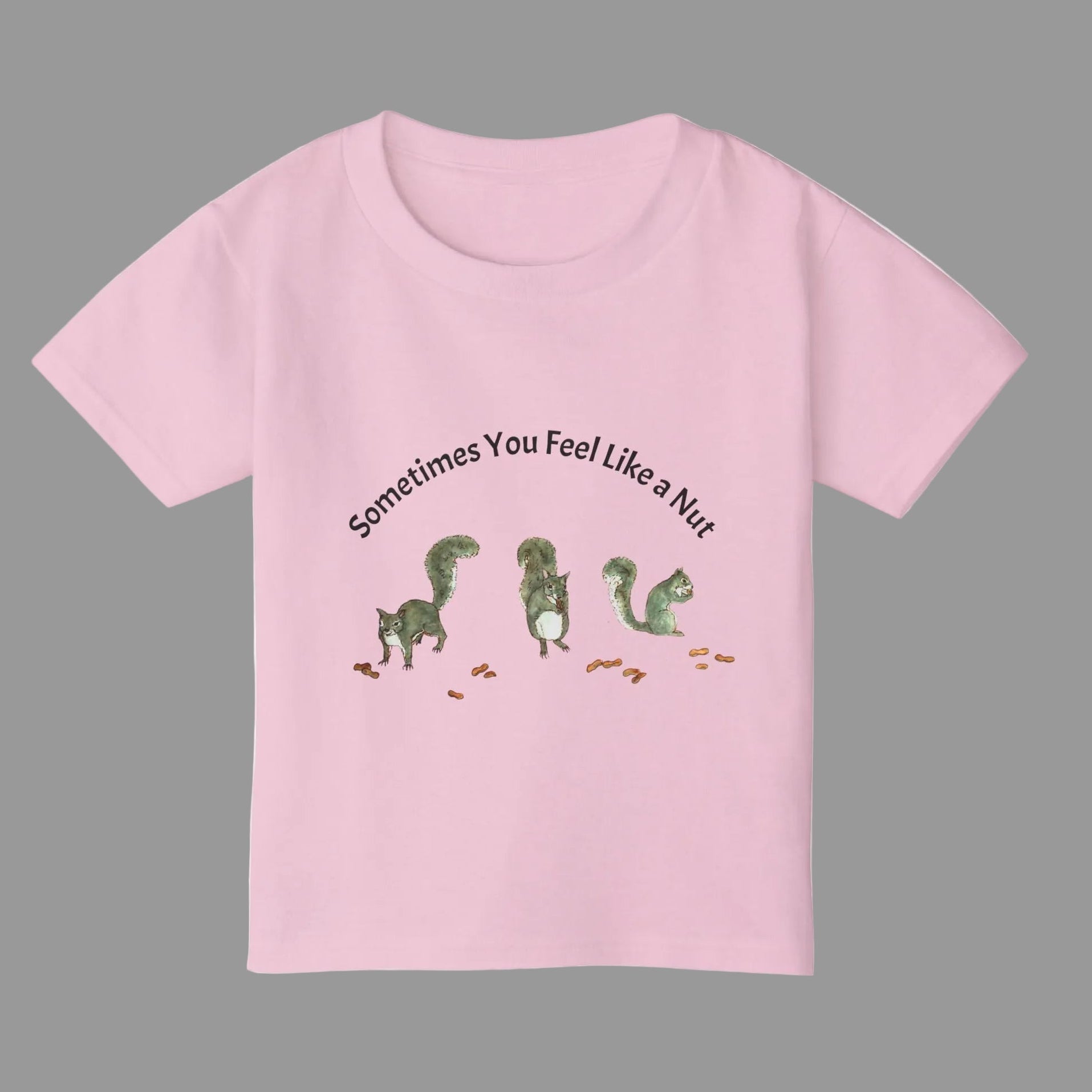 A light pink short-sleeve kids' t-shirt with a graphic of squirrels and the text 'Sometimes You Feel Like a Nut' 
