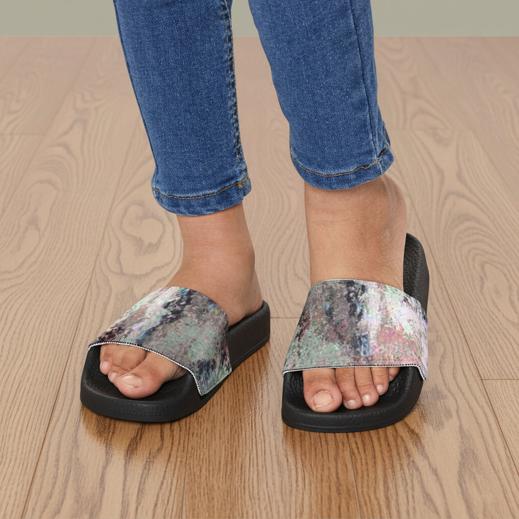 Youth's  black slide sandals with wide, iridescent shimmering straps in a pink, blue, and gray abstract design with cushioned soles