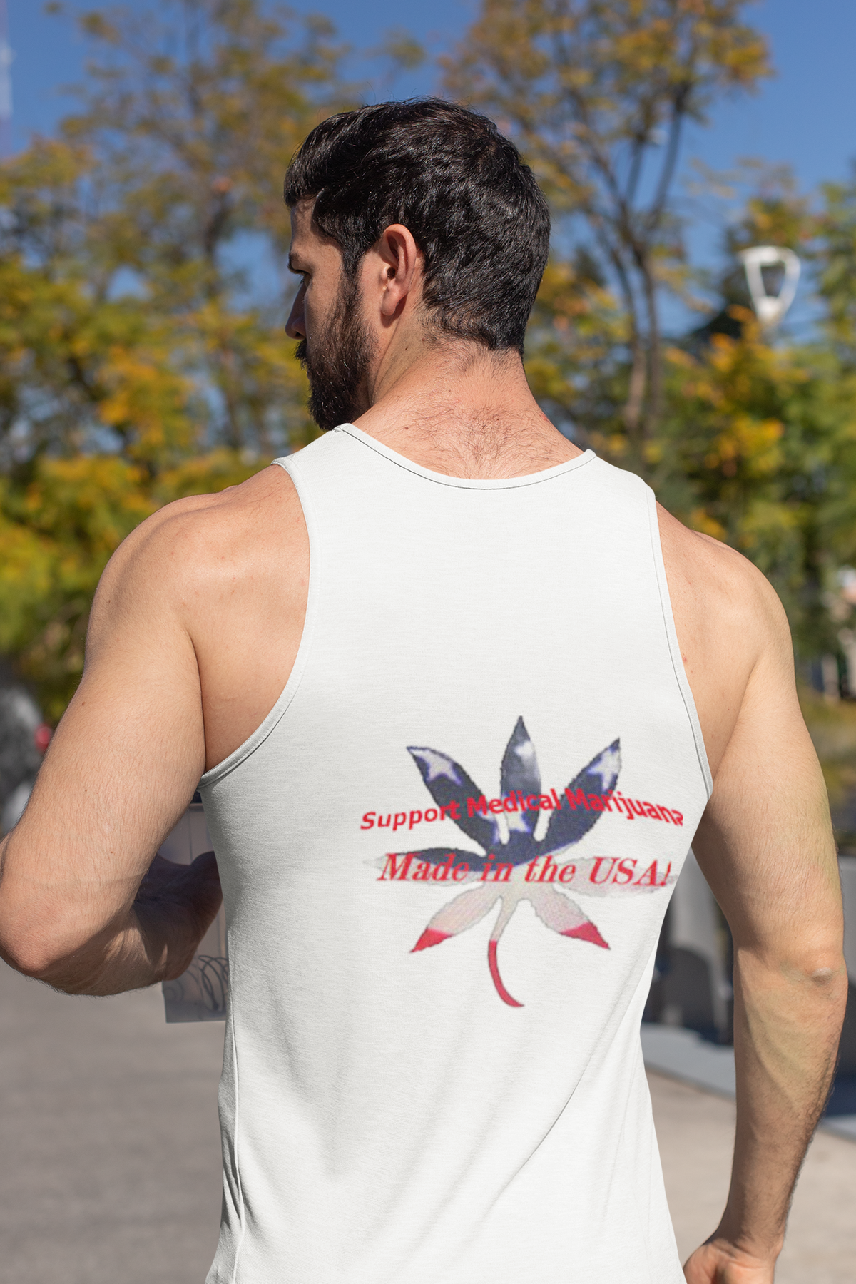 Viewed from behind - a white men's cotton tank top with a red, white, and blue marijuana leaf graphic and the text 'Support Medical Marijuana - Made in the USA' printed on the back
