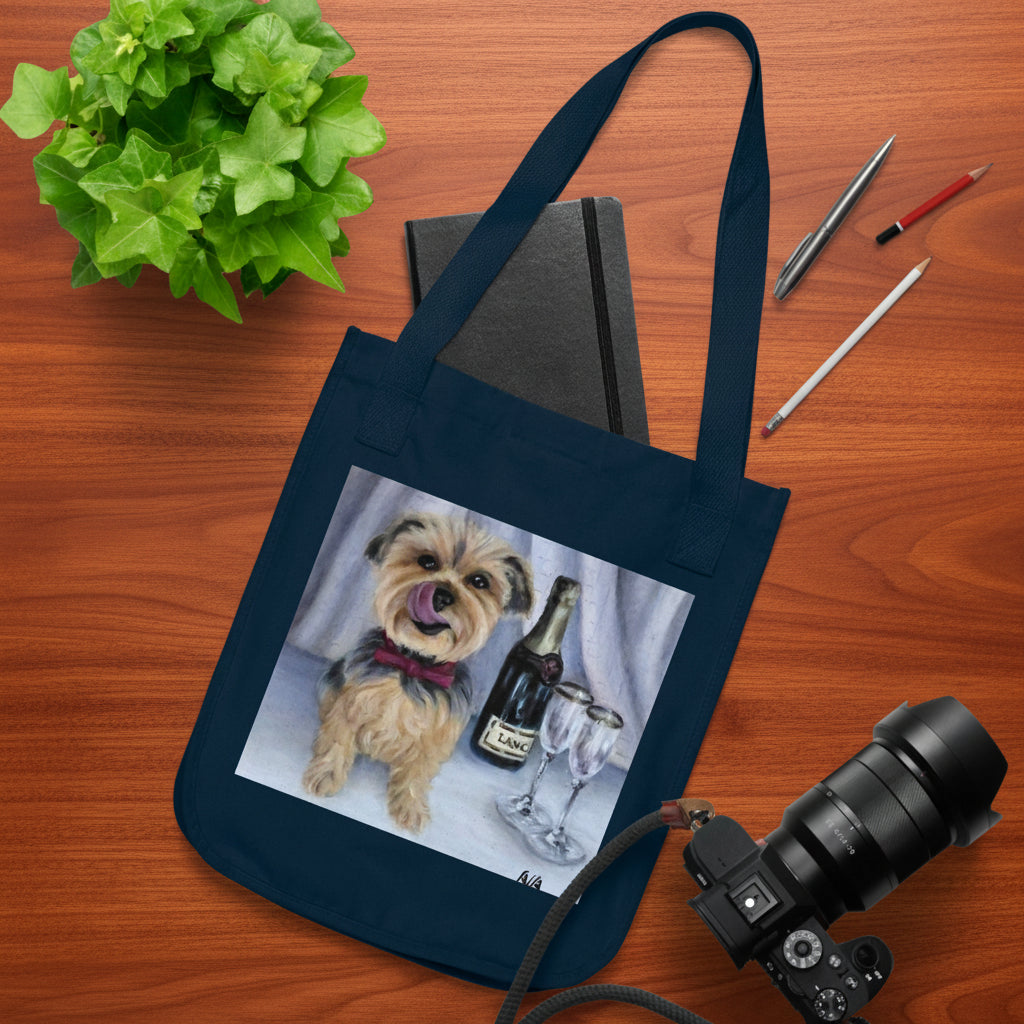A navy tote bag with a custom printed illustration of a small dog and champagne