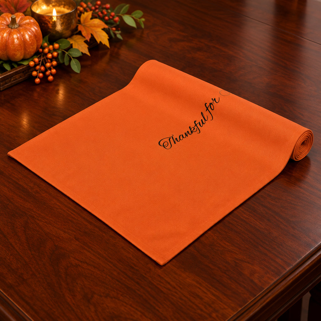 Orange table runner with 'Thankful for' text on a white background