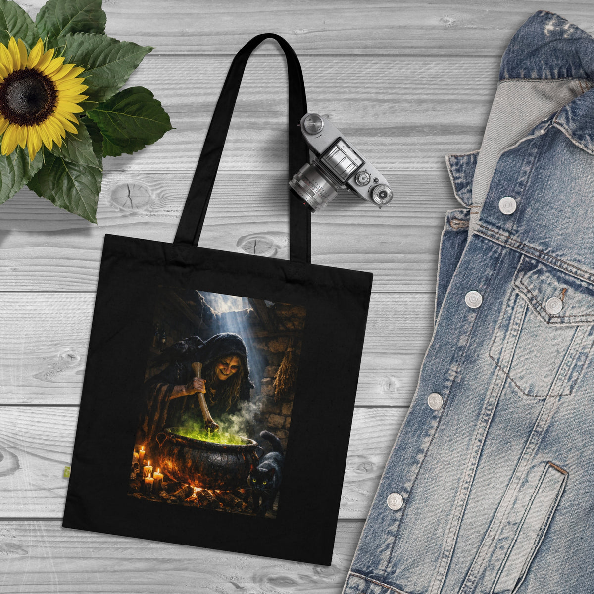 Black canvas tote bag with a witch brewing in a cauldron graphic for Halloween Season
