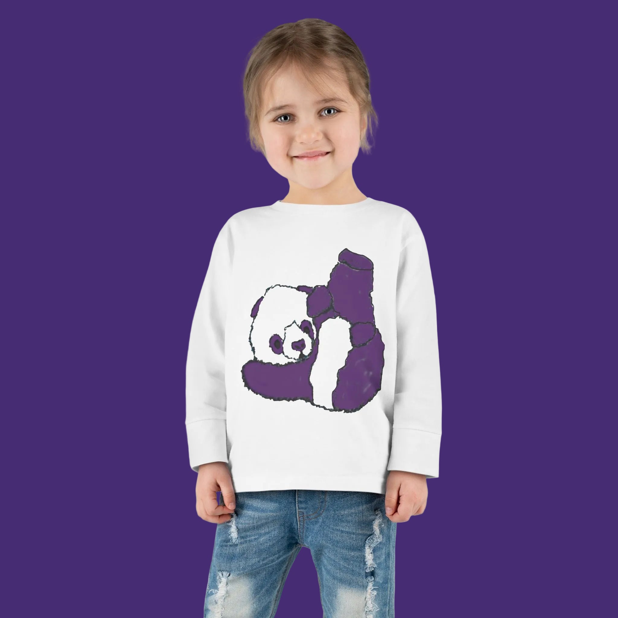 Child wearing a white sweater with a purple panda design on a purple background