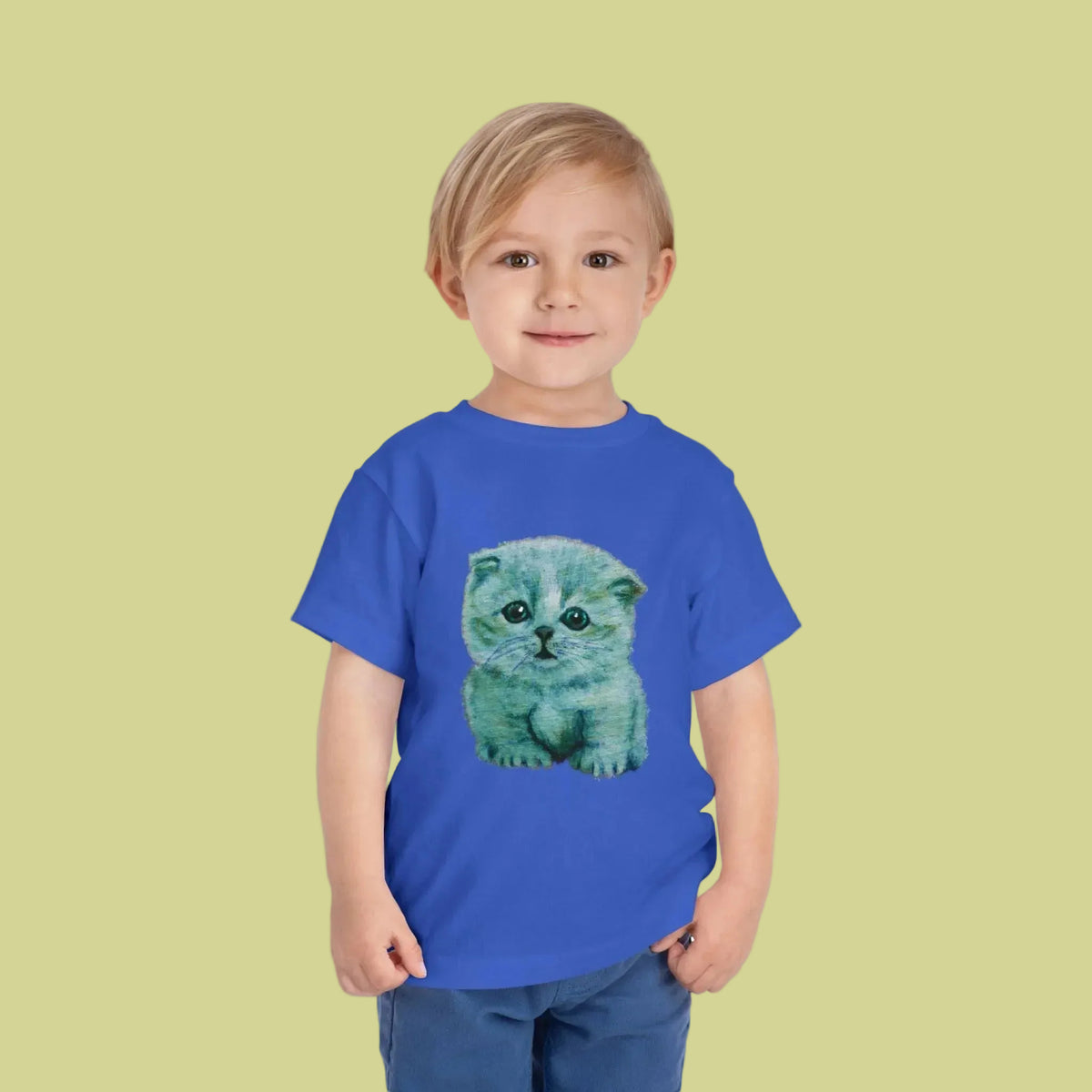 A toddler boy wearing a royal blue short-sleeve t-shirt with a green and blue kitten graphic on the front 2T-5T