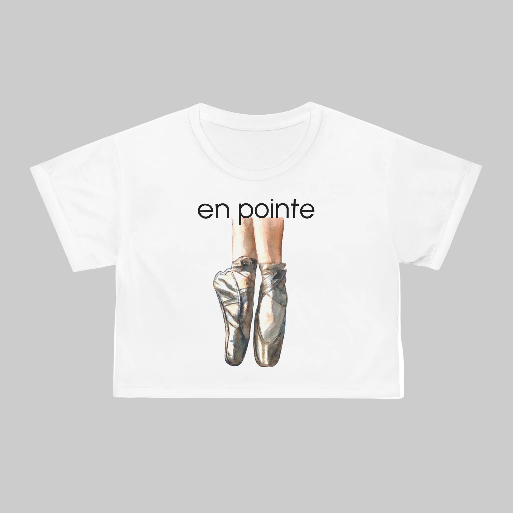 white short-sleeve crop tee features satin ballet pointe shoes with the text 'en pointe' - this Tee show seams with White Thread - black is also available.