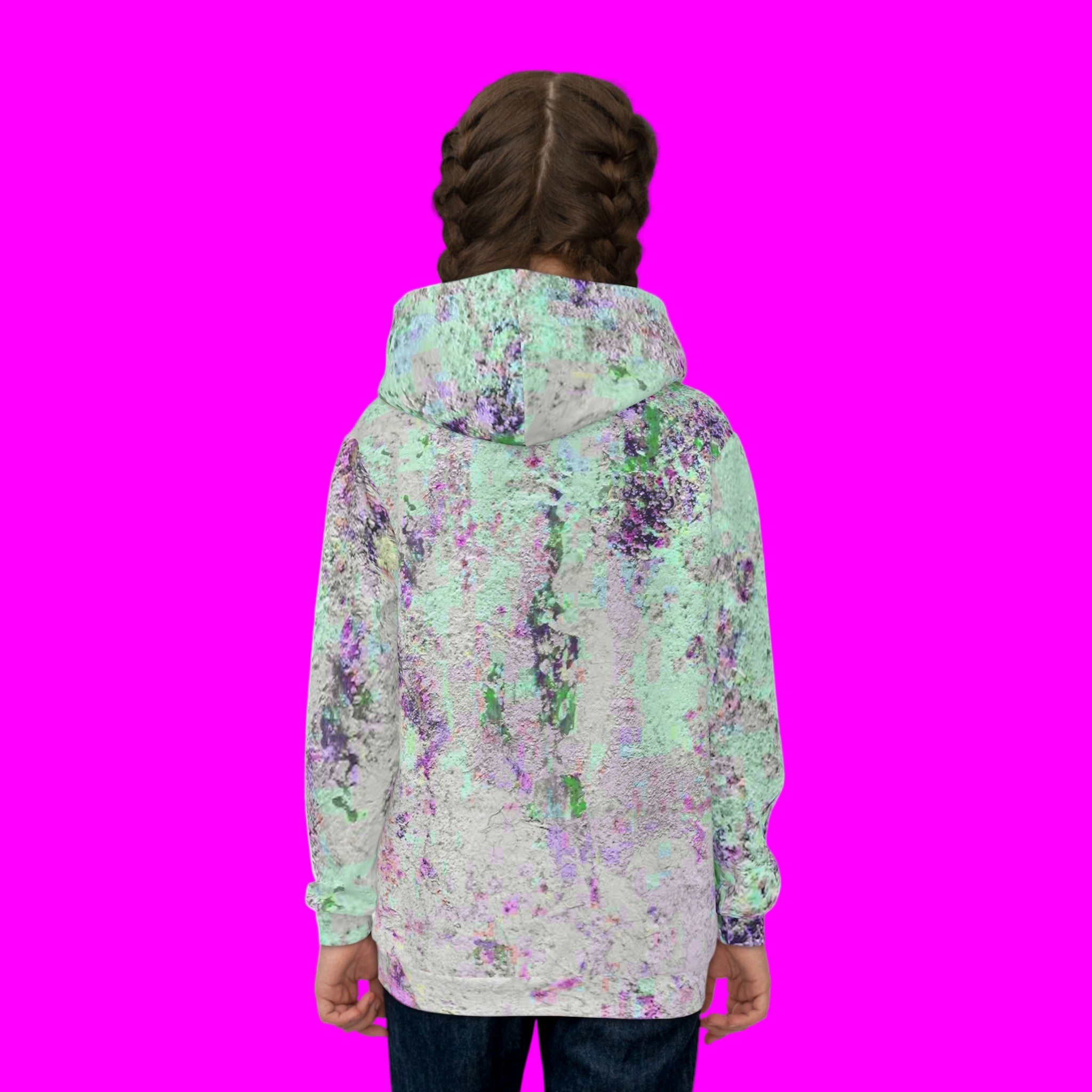 Person wearing a colorful abstract patterned jacket on a pink background