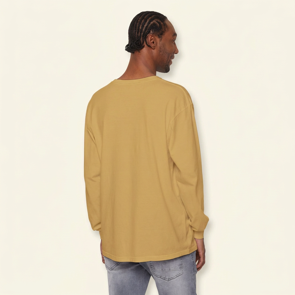 Back view of a man wearing a plain mustard gold long-sleeve tee and gray jeans.