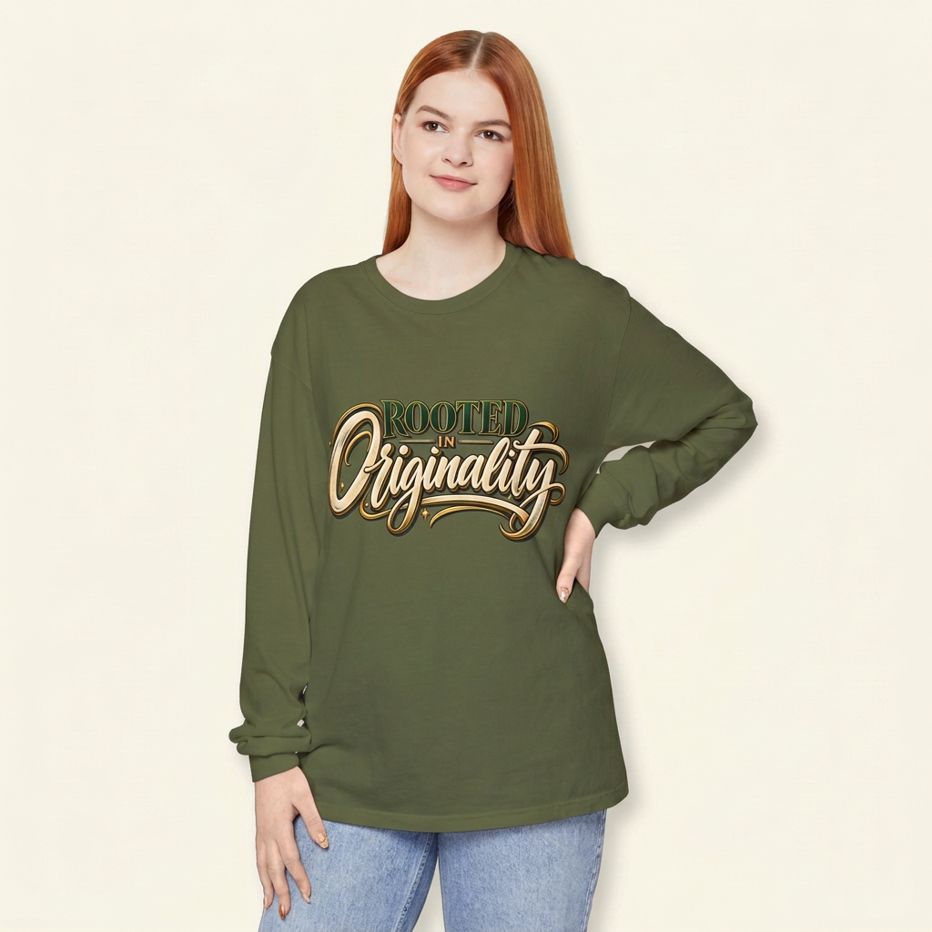Red-haired woman wearing an olive green Rooted in Originality long-sleeve tee, hand on hip.