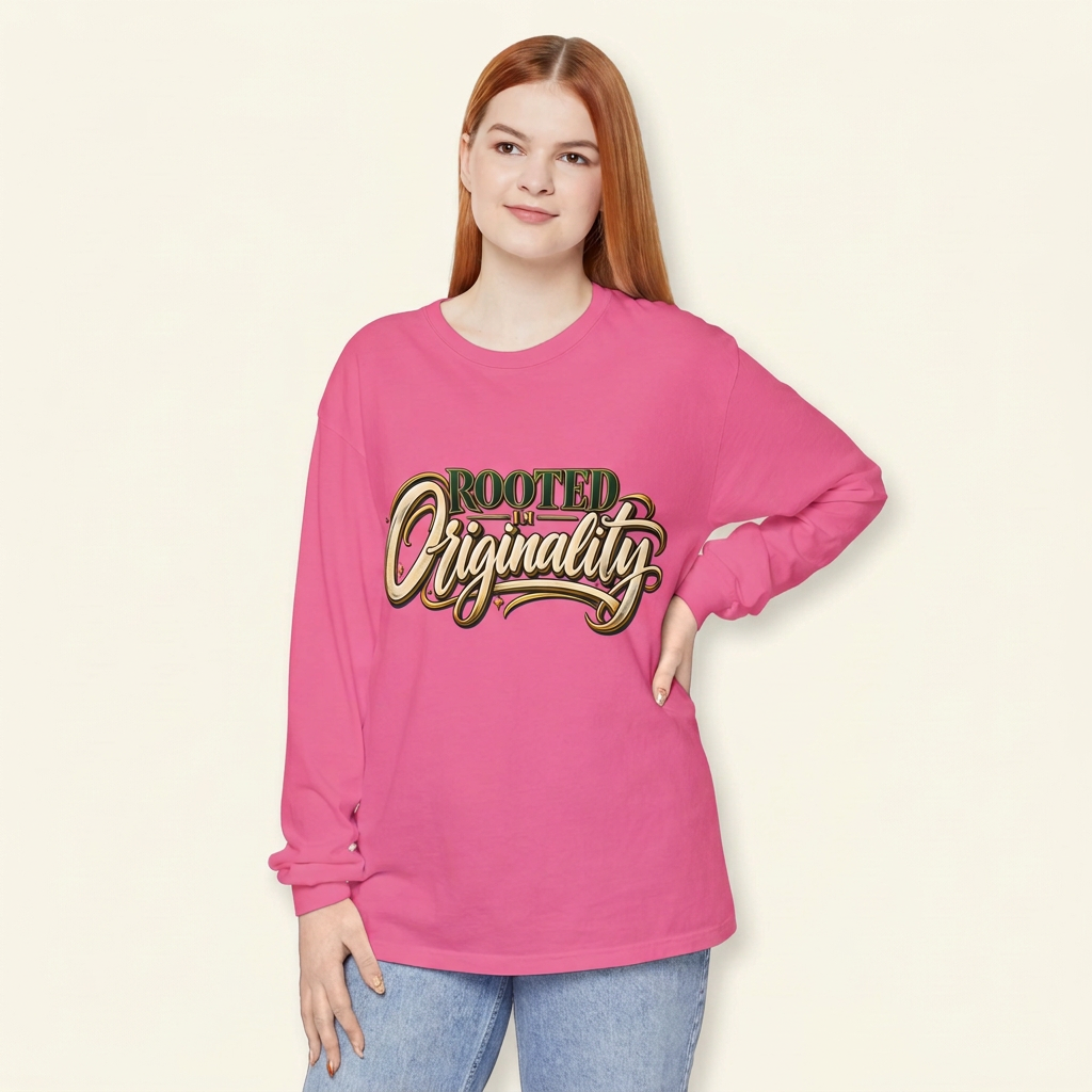 Red-haired woman wearing a pink Rooted in Originality long-sleeve tee, hand on hip.