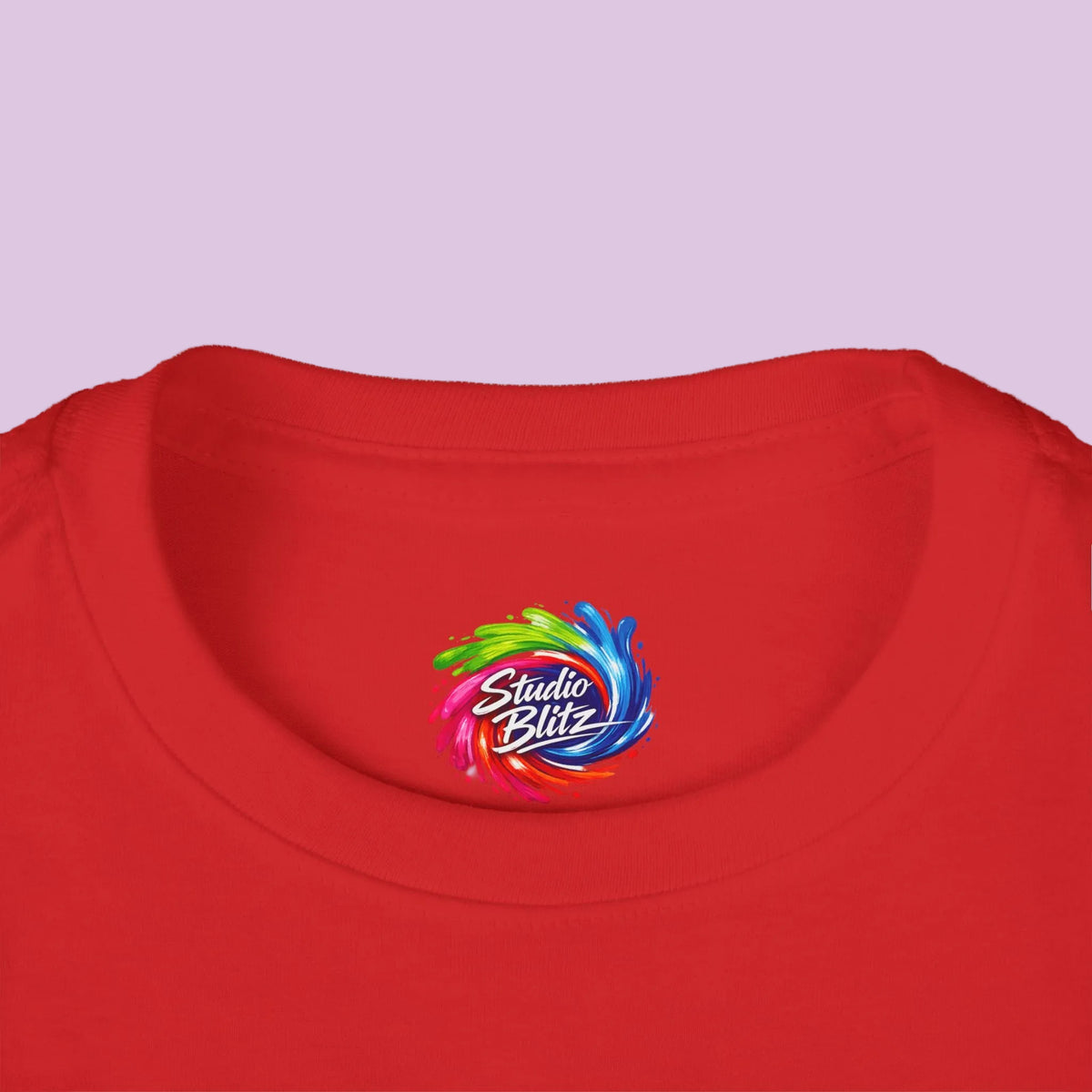 A close-up of a red crewneck t-shirt featuring a colorful 'Studio Blitz' logo printed on the inside 
